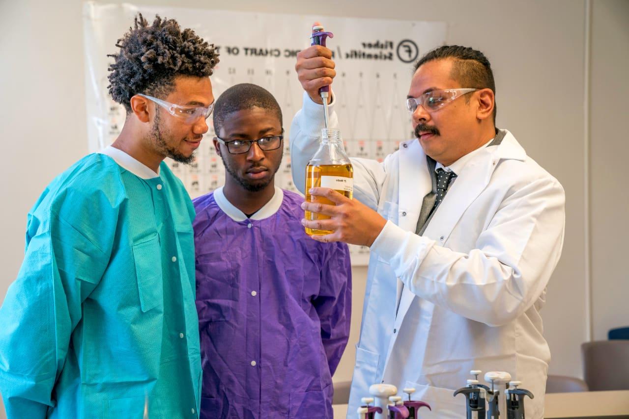 Students and professor working in science classroom